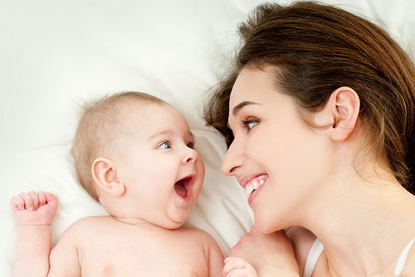 Happy-Mother-And-Happy-Baby-In-The-Bed